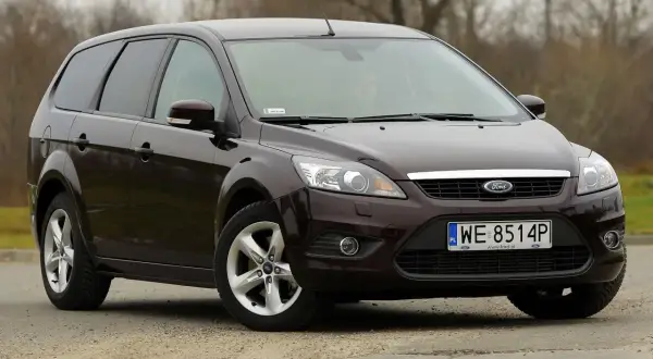 Ciemnobrązowy Ford Focus MK2 1.6 TDCI kombi stoi na szutrowej drodze.