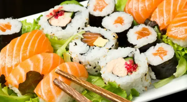 Talerz sushi z łososiem i warzywami. Czy sushi jest zdrowe? Tak, jeśli wybierasz świeże składniki i umiarkowane porcje ryżu.