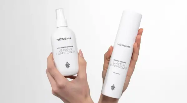 Zwei NEWSHA Leave-In Conditioner Flaschen in Händen. Was ist ein Leave-In Conditioner? Pflege, die im Haar bleibt.