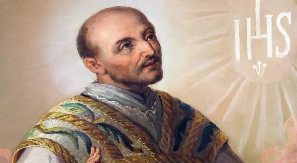 Święty Ignacy Loyola, którego wspomnienie przypada na 31 lipca, w chwale niebios. Widnieje symbol IHS.