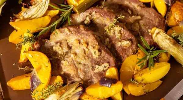 Saftiges Schweinesteak im Backofen ohne Anbraten, umgeben von goldbraunen Kartoffelspalten, Fenchel und Kräutern.