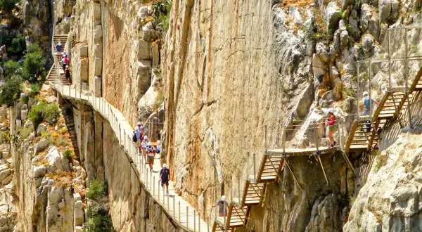 Vandrare på den dramatiska gångvägen Caminito del Rey nära Málaga, högt uppe på klippväggarna.