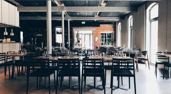 Rader av dukade bord med svarta stolar i en modern lokal. Kanske är det här the picts bar ligger, redo för kvällens gäster.