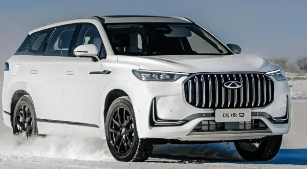 Biały Tiggo 9 pokonuje śnieżne tereny, prezentując swój imponujący grill i elegancką sylwetkę.
