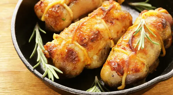 Involtini di pollo in padella con sughetto e rosmarino, dorati e succulenti, pronti per essere gustati.