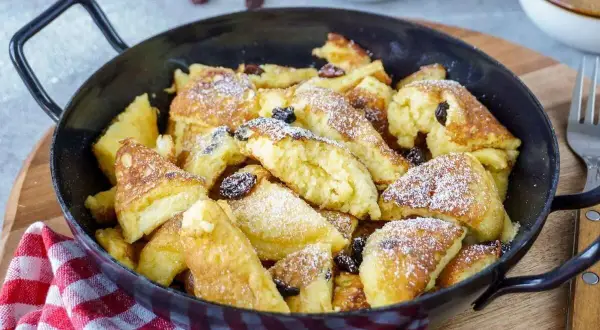 Ein köstlicher Kaiserschmarrn, frisch aus der Pfanne, mit Rosinen und Puderzucker bestäubt. Ein einfaches Rezept für Genuss.