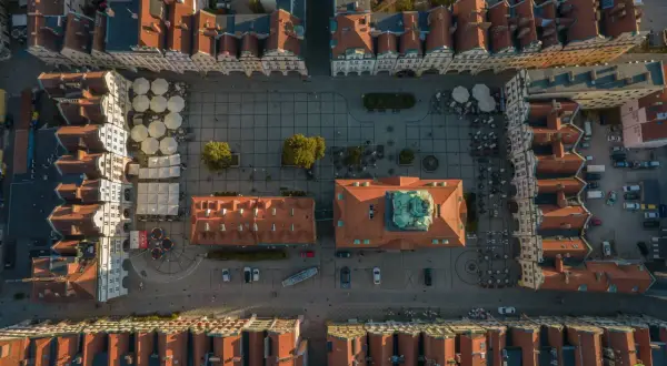 Widok z lotu ptaka na rynek w Jeleniej Górze. Widać kolorowe kamienice, kawiarniane ogródki i zabytkowy ratusz. To świetne miejsce na odkrywanie jeleniogórskich atrakcji.