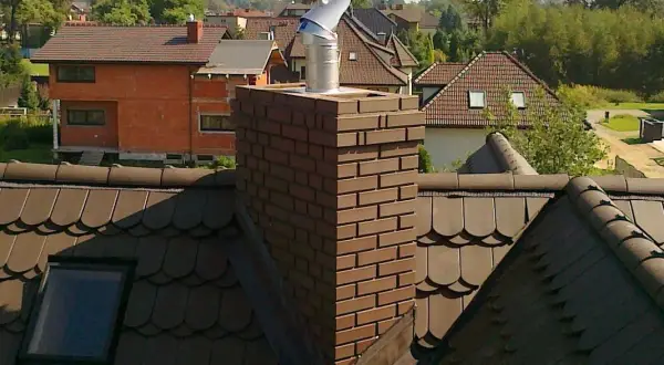 Metalowy daszek na kominie, chroniący przed deszczem. Pokazuje, jak zrobić daszek na komin, by był skuteczny.