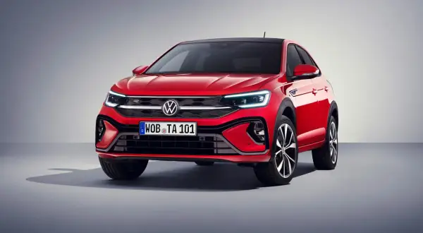 Czerwony Volkswagen Taigo z czarnym dachem prezentuje się dynamicznie. Eleganckie linie i nowoczesne światła podkreślają jego sportowy charakter.