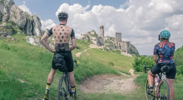 Dwie osoby na rowerach podziwiają ruiny zamku na Jurze. Idealne trasy rowerowe Częstochowa czekają na odkrycie!