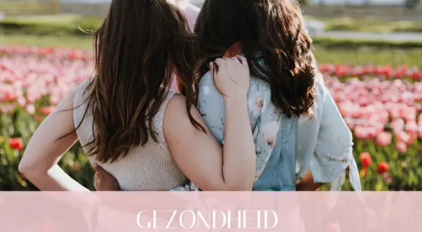 Twee vriendinnen omhelzen elkaar in een bloemenveld. Een warme omhelzing die de kracht van hsp en vriendschap symboliseert.