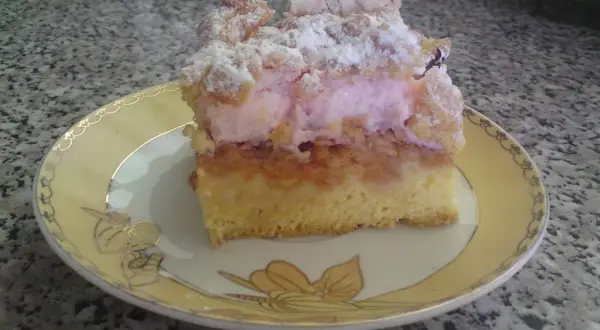Pyszny placek z jabłkami i różowym kisielem, posypany cukrem pudrem. Idealny na deser.