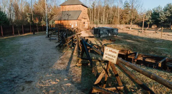 Drewniana wieża i okopy w Tomaszowie Mazowieckim. Ostrzeżenie "Uwaga! Gębokie wykopy" przypomina o historii tego miejsca.