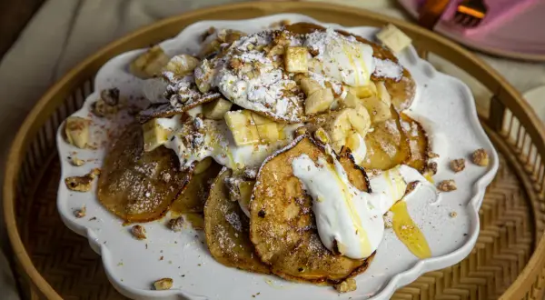 En härlig pannkakstårta med glass, banan och nötter. Pudrad med florsocker och ringlad med honung.