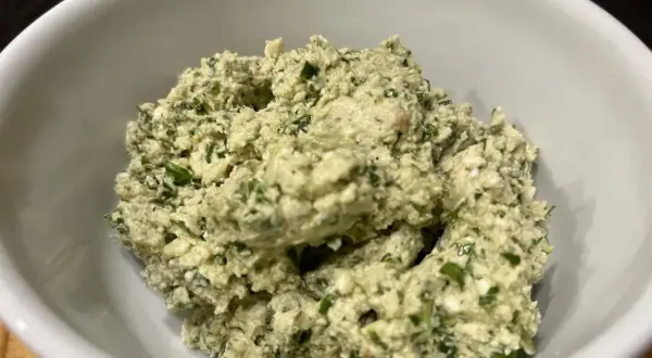 Frisch zubereitetes Moretum-Rezept in einer weißen Schüssel, ein cremiger Käseaufstrich mit Kräutern.