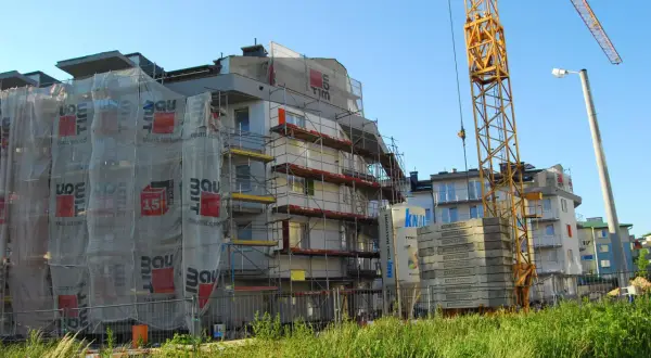 Budowa bloku mieszkalnego, rusztowania, dźwig. Ciekawe, ile zarabia deweloper miesięcznie, patrząc na takie inwestycje.