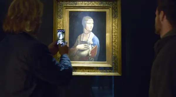 Dama z gronostajem w Muzeum Książąt Czartoryskich w Krakowie. Kobieta robi zdjęcie obrazu telefonem.