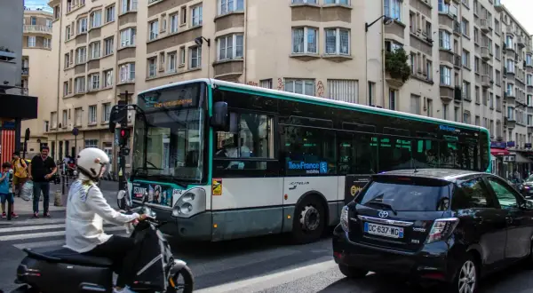 Paryż: autobus miejski i skuter na ulicy, symbolizujące dojazd do centrum z lotniska Charles de Gaulle.