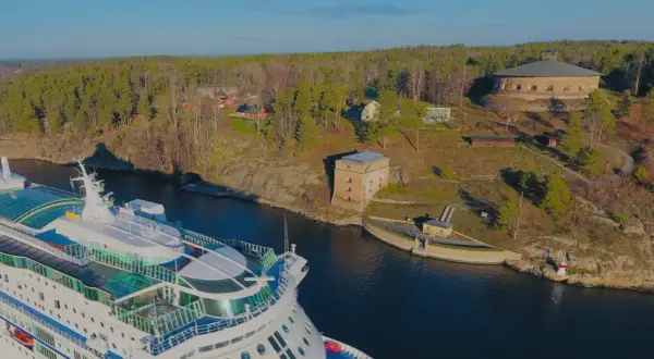 Kryssningsfartyg passerar Fredriksborgs hotell och fästning i en vacker svensk skärgårdsmiljö.