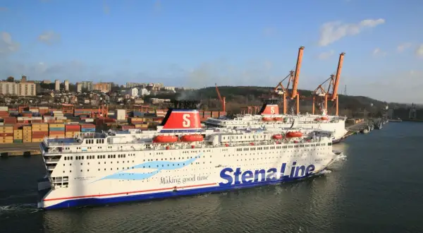 Dwa promy Stena Line w porcie, z widokiem na miasto i dźwigi.