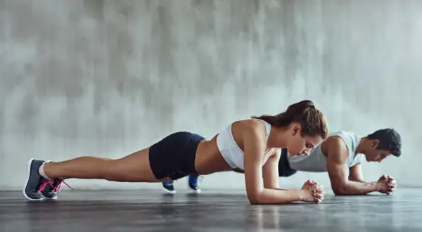 Para ćwiczy plank, co to trening core. Wzmacniają mięśnie brzucha i pleców.