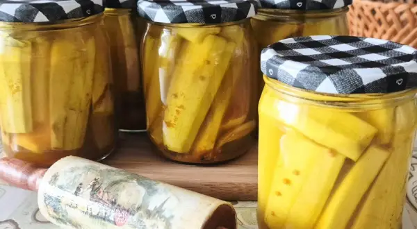 Słoiki z cukinią w zalewie słodko-kwaśnej z curry, gotowe do spiżarni.