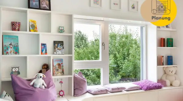 Gemütliches Kinderzimmer mit Bücherregalen, Spielzeug und einem Fensterplatz, der zum Entspannen einlädt. Ein schönes Beispiel für ein kinderfreundliches Zimmer, das auch ohne Fenster hell wirkt.