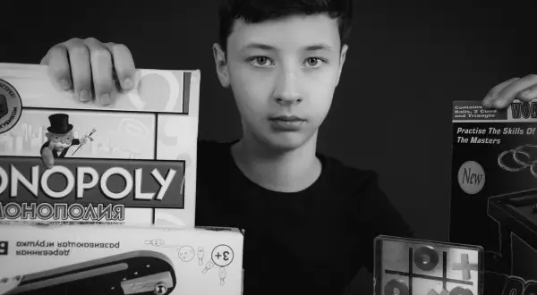 Chłopiec prezentuje gry: Monopoly, kółko i krzyżyk, bilard. Idealna gra dla jednej osoby, by rozwijać umiejętności.