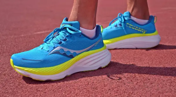 Niebieskie buty na półmaraton z żółtymi akcentami, gotowe do biegu na bieżni.
