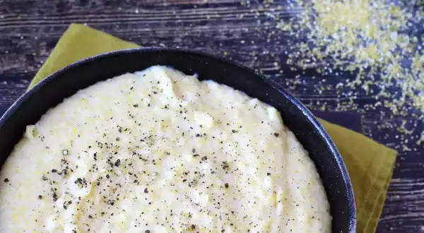 Krämig polenta i gjutjärnspanna, strödd med peppar. Perfekt för ett enkelt polenta recept.