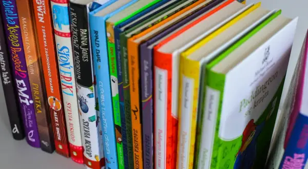 Kolorowe grzbiety książek, w tym "Paddington się krząta", idealne jako książka dla 6 latka chłopca.