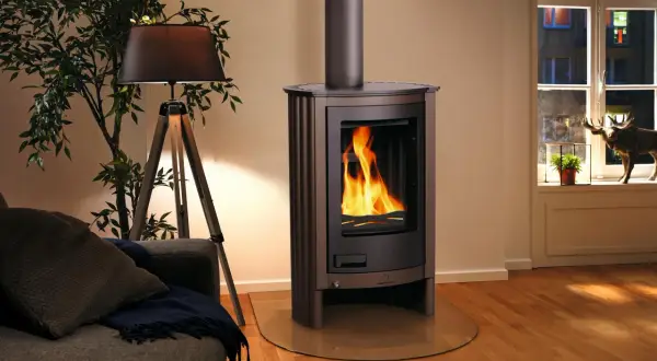 Stufa a legna nordica accesa, con fiamme vive. Un'idea su come pulire la stufa a legna nordica per mantenerla efficiente e bella.