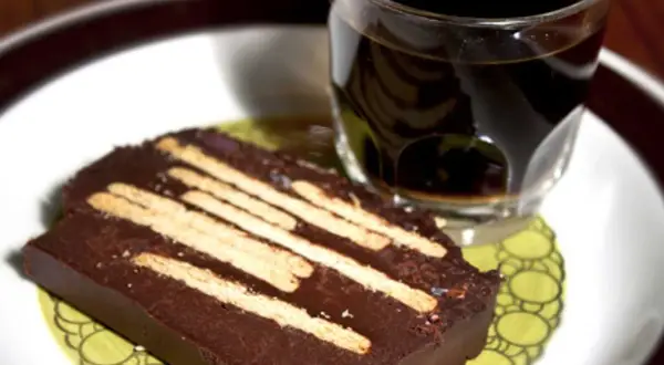 En bit chokladkaka med kex, perfekt för ett radiokaka recept original. Serveras med en kopp kaffe.