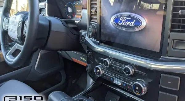 Intérieur du camion Ford F-150 : volant, écran tactile avec logo Ford, tableau de bord numérique et console centrale.
