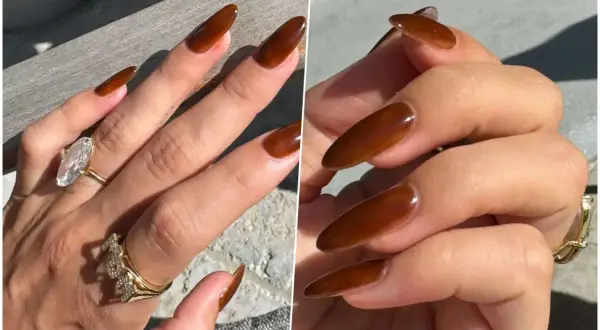 Manucure marron élégante sur des ongles longs et pointus, ornés de bagues scintillantes.