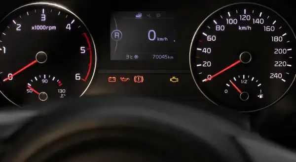 Tableau de bord d'une voiture avec indicateurs allumés, dont le voyant moteur. Le kilométrage est de 70045 km. Ce n'est pas une liste voyant Iveco.