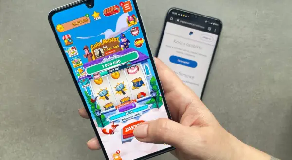 Gra Coin Master na telefonie, obok ekran z PayPal. To jedne z gier do zarabiania pieniędzy, które pozwalają na zdobywanie wirtualnych środków.