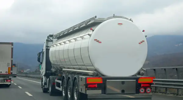 Camion-citerne blanc sur l'autoroute, prêt pour le transport. L'autorisation de rouler pour les camions est essentielle pour la logistique.