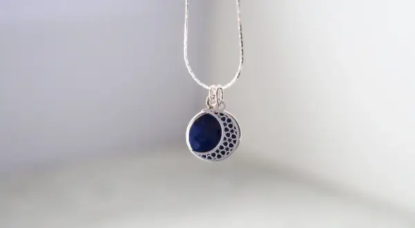 Srebrny wisiorek z lapis lazuli w kształcie półksiężyca. Dowiedz się, jak wyczyścić srebrną biżuterię z kamieniami, by zachować jej blask.