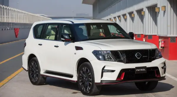 Biały Nissan Patrol Nismo z czerwonymi akcentami stoi na torze wyścigowym.