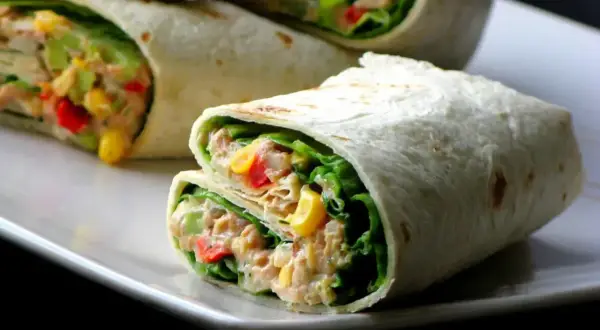 Pyszna tortilla z tuńczykiem, chrupiącą sałatą, kukurydzą i papryką. Idealna na szybki lunch.