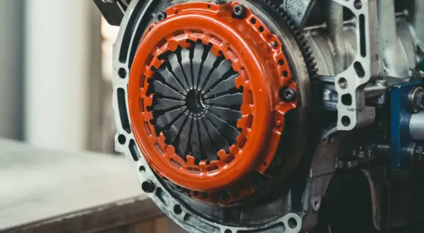 Mechanizm sprzęgła z pomarańczową osłoną. Zastanawiasz się, ile kosztuje wymiana dwumasy?