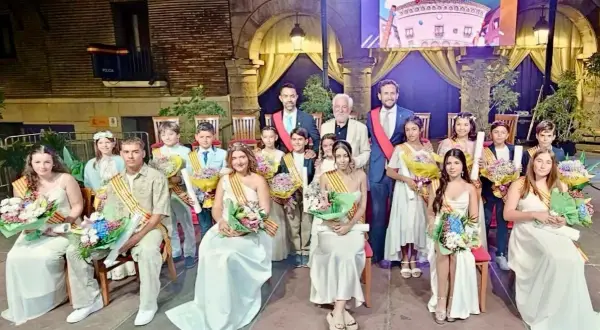 Jóvenes y adultos celebran las fiestas de Monzón, luciendo trajes elegantes y portando ramos de flores.