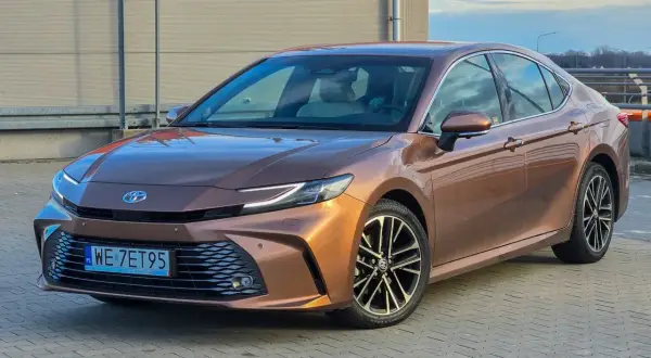 Brązowa Toyota Camry 2.5 Hybrid prezentuje się elegancko, a jej niskie spalanie to atut dla kierowców.