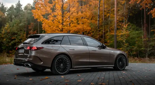 Elegancki Mercedes E300de kombi na tle jesiennego lasu.