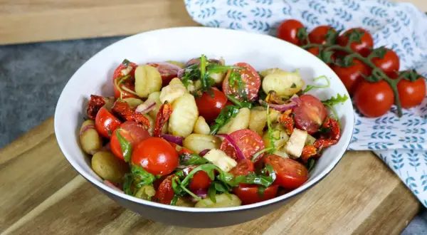 Leckerer Gnocchi Salat mit Kirschtomaten, getrockneten Tomaten, roter Zwiebel und Rucola. Ein leichter Genuss!