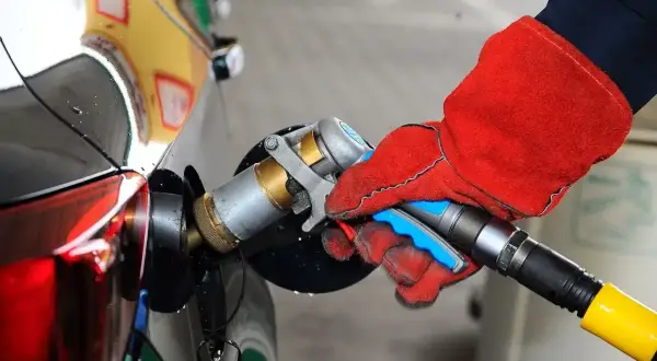 Ręka w czerwonej rękawicy podłącza pistolet do tankowania LPG. To proste tankowanie dla początkujących.