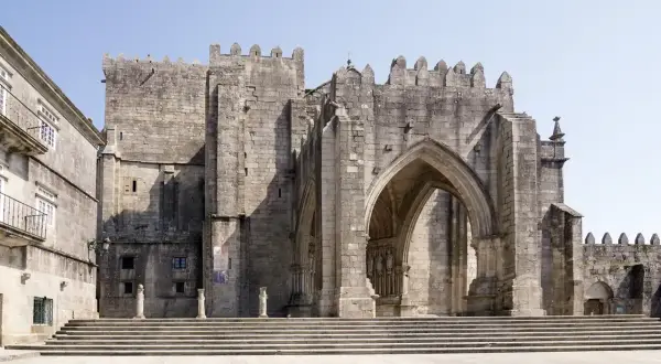 La imponente catedral de Tui se alza majestuosa, con sus escalinatas y arcos de piedra que invitan a explorar su historia.