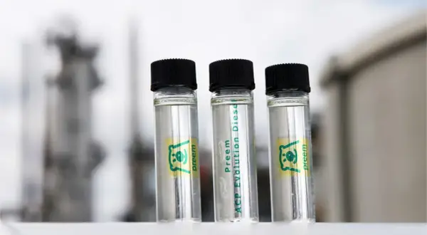 Tre små provrör med Preem Evolution Diesel står framför en industriell bakgrund.