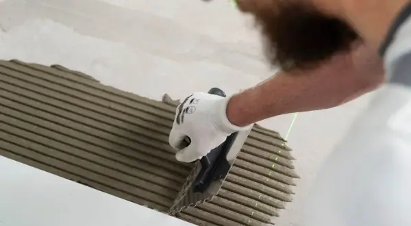 Pose d'enduit pour carrelage au sol. Le temps de séchage carrelage sol est crucial pour une pose réussie.